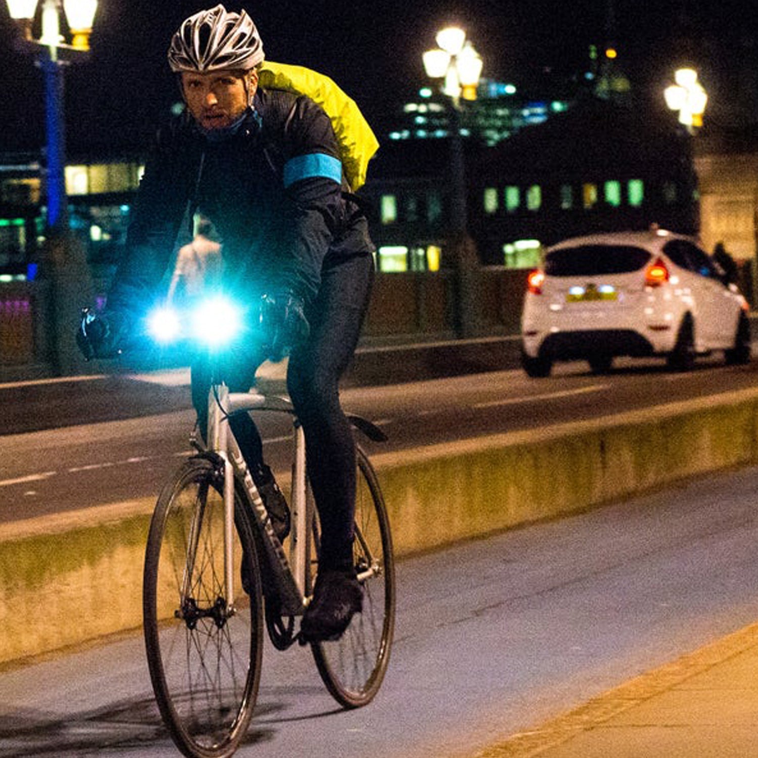 Cyclist riding at night with a bright front bicycle light